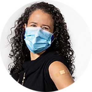 Gabriela Maradiaga Panayotti in a face mask and with bandaid on shoulder from vaccine