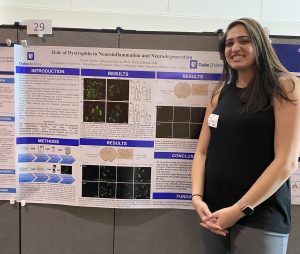ElMallah Lab Member in front of Research Poster