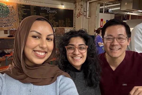 Three people smiling together in a cafe setting
