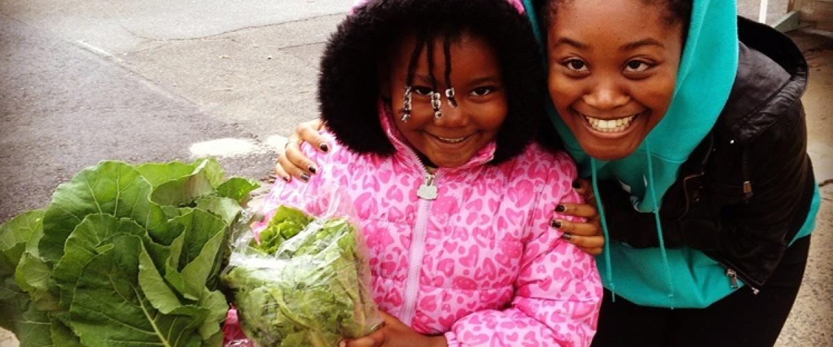 Mother and child smiling holding lettuce