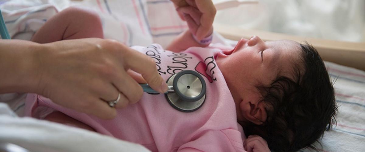 Infant being checked with stethoscope