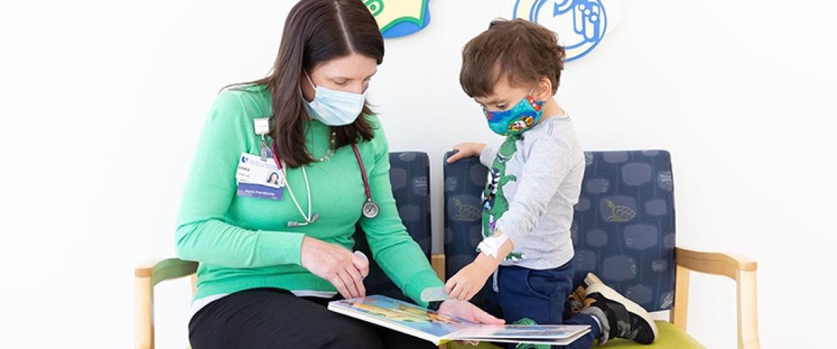 Provider reading a book with child patient