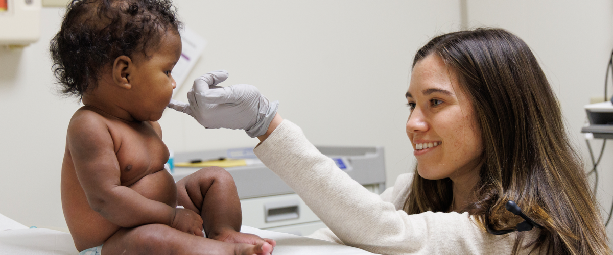 Pediatric trainee examining a child