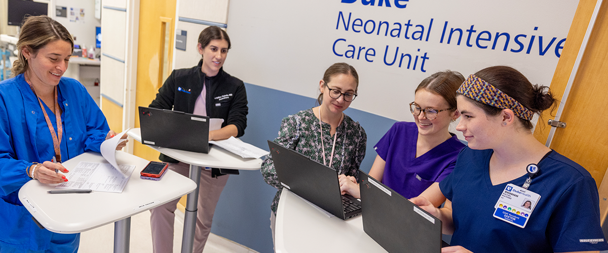 Residents with fellow looking at computers in NICU
