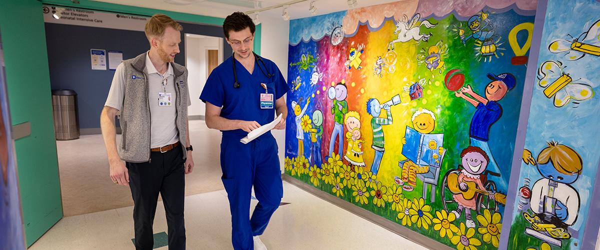 Two residents walking in a colorful hallway