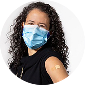 Gabriela Maradiaga Panayotti in a face mask and with bandaid on shoulder from vaccine