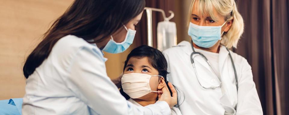 Two nurses with pediatric patient