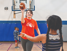 Girl throwing football in gym